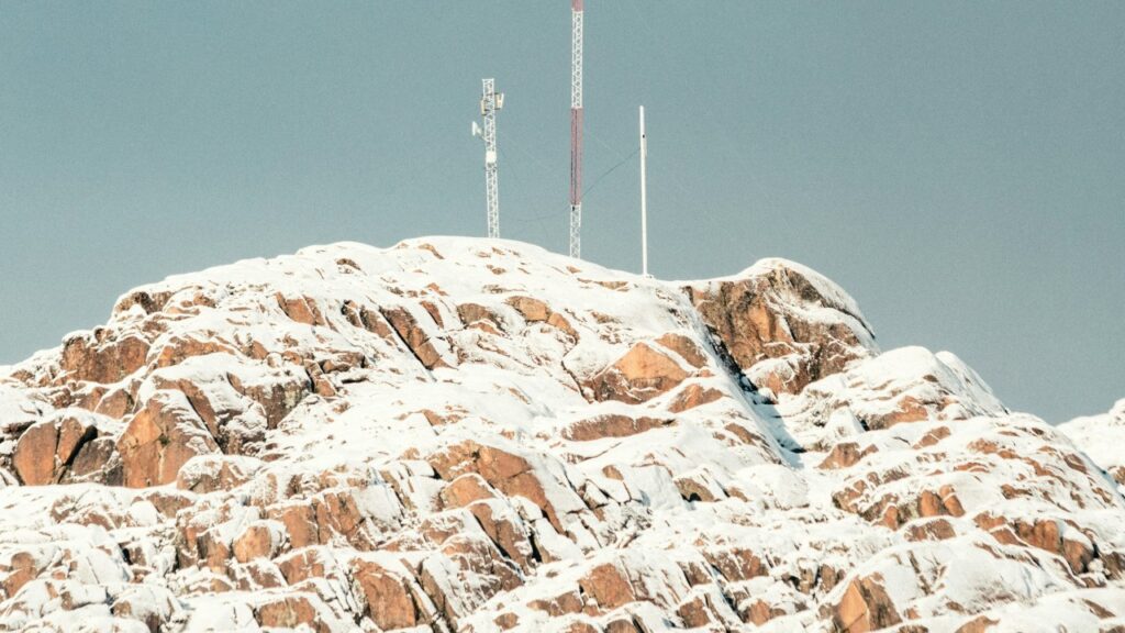 Montaña cubierta de nieve y, en la cumbre, unas antenas.