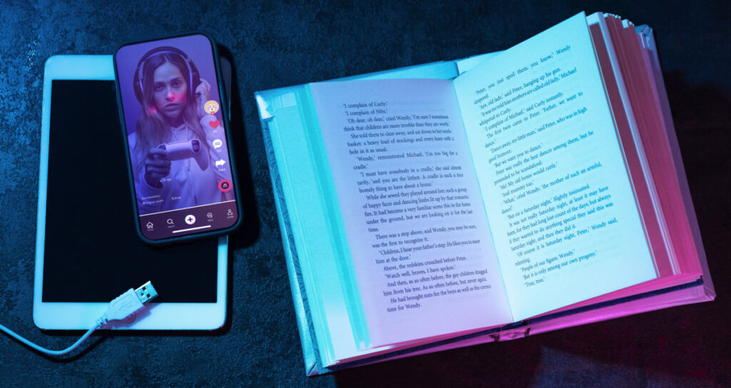 Fotografía de un libro en papel, una tableta y un teléfono móvil